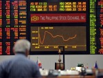 A trader looks at the electronic board showing the downward graph of the stocks price index at the Philippine stock exchange. AFP