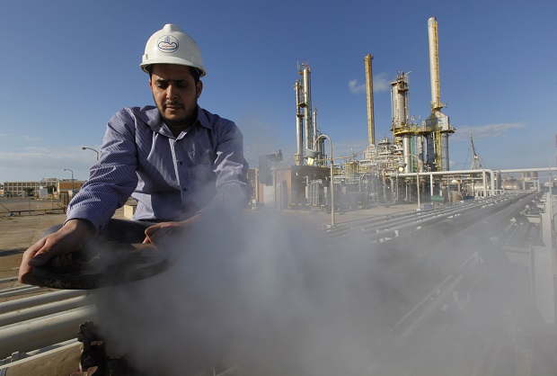 FILE - In this Feb. 26, 2011, file photo, an employee works at a refinery inside the Brega oil complex, in Brega, eastern Libya. OPEC produces one-third of the worlds oil and, in theory, at least, can affect global oil prices depending on how much oil it decides to sell. In reality, OPEC member countries have different, often conflicting priorities and dont adhere to the cartels official targets for production. (AP Photo/Hussein Malla, File)