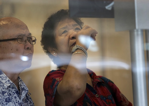 People look at Hong Kong share index at a local bank in Hong Kong, Monday, Aug. 24, 2015. Stocks got a dismal start to the week in Asia, with Chinas main index losing up to 8.6 percent Monday as investors shaken by the sell-off last week on Wall Street unloaded shares in practically every sector.(AP Photo/Vincent Yu)