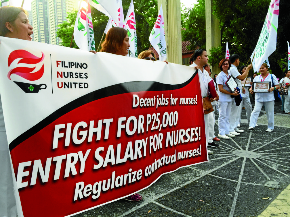 Members of Filipino Nurses United march to Philippine General Hospital on Taft Avenue in Manila to call on government to stop contractualization of nurses and standardize their starting pay at P25,000. 