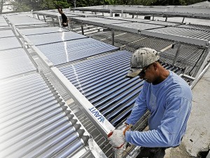 A MAINTENANCE crew puts finishing touches on a solar panel installed on the rooftop of St. Augustine building in La Consolacion College Manila, Mendiola. ANDREW TADALAN