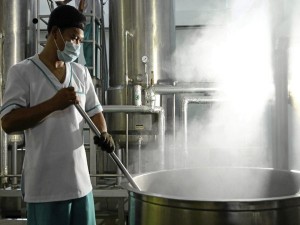 A WORKER stirs heated sugarcane juice at the Raw Brown Sugar Milling Co. Inc. muscovado factory.