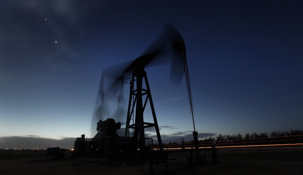 In this file photo taken with a long exposure, a pumping unit sucks oil from the ground near Greensburg, Kan. AP FLE PHOTO