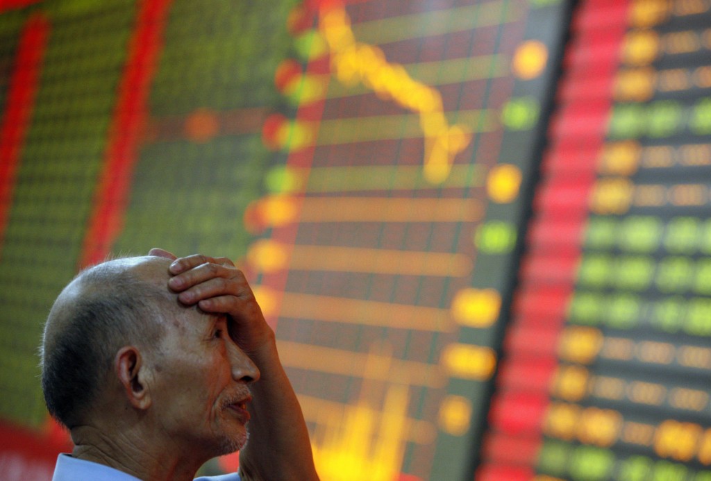 A stock investor reacts near a board displaying stock prices at a brokerage house in Huaibei in central China's Anhui province on Monday June 24, 2013. Asian markets mostly fell on Tuesday owing to growing concerns about a liquidity crisis in China.  AP PHOTO 