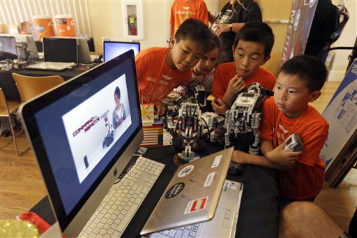 Children look at a computer presentation on how to assemble Lego parts during a Digital Media Academy workshop in Stanford, California on Agust 14. AP 