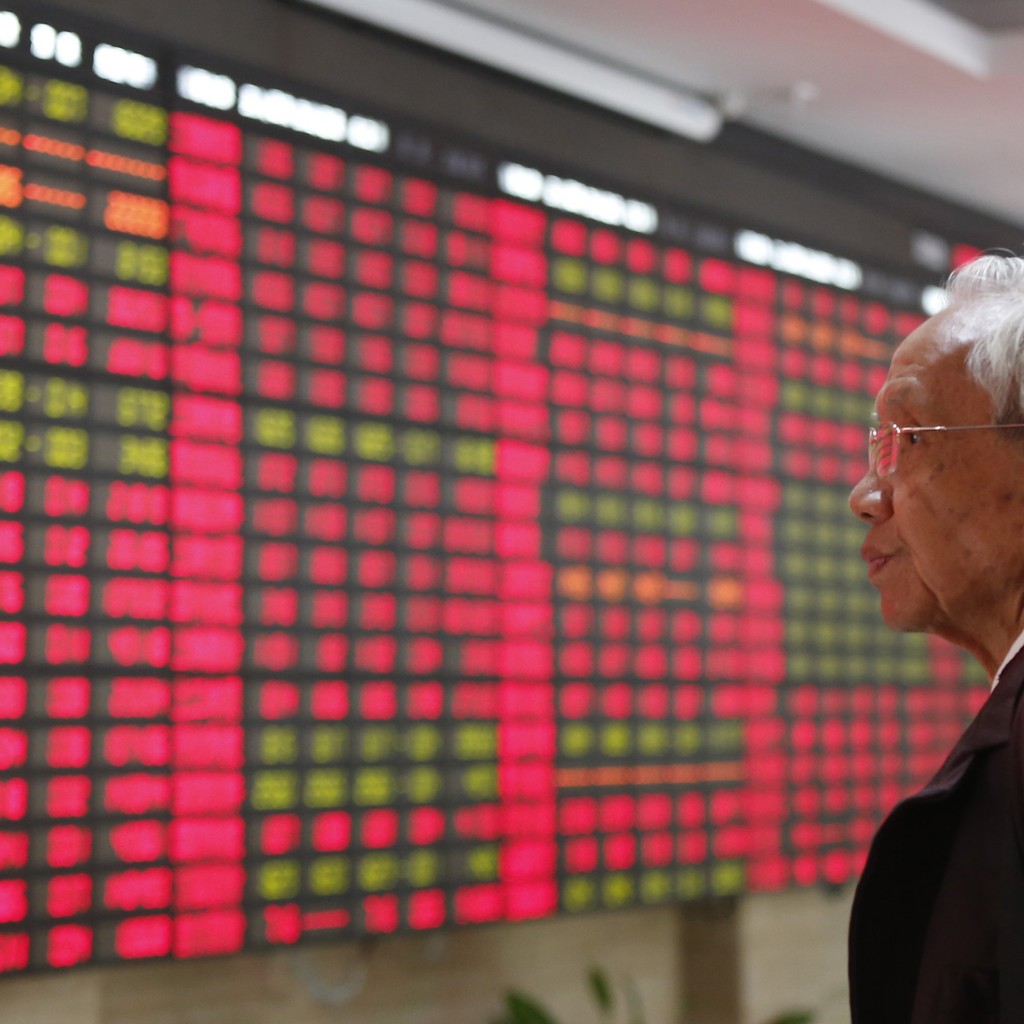 An investor looks at the stock price monitor at a private securities company Monday, Nov. 25, 2013, in Shanghai, China. Asian markets were mixed on Tuesday following a muted lead from Wall Street.  AP PHOTO 