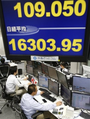 Workers of a foreign exchange dealing company monitor electric screens, under the US dollar rate against the Japanese yen, top, and Nikkei stock index, bottom, in Tokyo on Sept.19, 2014. Asian markets mostly slipped Monday, Sept. 22, on profit-taking after the big gains at the end of last week, while the dollar eased from more than six-year highs against the yen.  AP PHOTO/SHIZUO KAMBAYASHI 