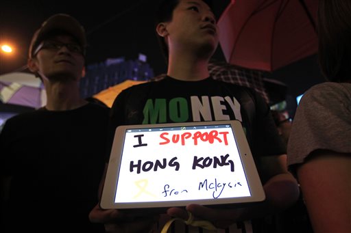 A Malaysian activist holds an iPad tablet computer showing words "I support Hong Kong" during a rally in Kuala Lumpur, Malaysia. AP