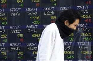A man walks past an electronic stock board of a securities firm in Tokyo on Oct. 28, 2014. Asian markets rose Wednesday, Oct. 29, following strong gains on Wall Street, as traders awaited news from the US Federal Reserve about interest rate plans for the world's largest economy.  AP PHOTO/EUGENE HOSHIKO