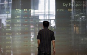 An Indonesian man watch an electronic stock board at the Jakarta Stock Exchange in Jakarta, Indonesia, Thursday, Oct 2, 2014. Asian stocks fell Thursday amid worries about the strength of US and European recoveries and the first American case of Ebola.  AP PHOTO/ACHMAD IBRAHIM 
