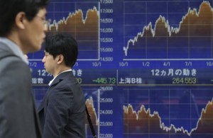 People walk by an electronic stock board of a securities firm in Tokyo on Oct. 10, 2014. Asian markets rose Wednesday, Oct. 15,with bargain-hunters providing some lift after recent losses while data showing Chinese inflation at a five-year low raised hopes for fresh economy-boosting measures from Beijing.  AP PHOTO/KOJI SASAHARA 