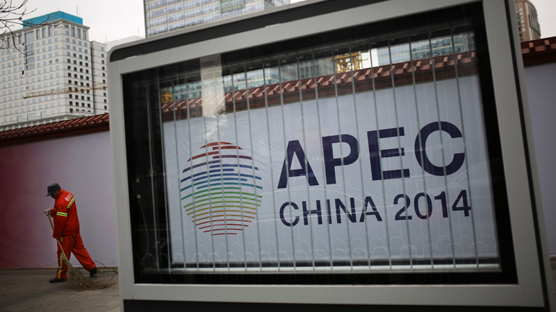 A cleaner swept a pavement near a APEC China 2014 logo on display near a construction site at the Central Business District in Beijing, China Tuesday, Nov. 11, 2014. Chinese President Xi Jinping called on Asia-Pacific leaders Tuesday to strengthen trade ties at a summit Beijing is using to boost its role as a regional power with a flurry of trade and finance pacts. (AP Photo/Andy Wong)