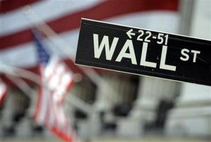 File photo shows a Wall Street sign near the flag-draped facade of the New York Stock Exchange. US Stocks wavered between small gains and losses on Thursday to close little changed as traders weighed generally strong earnings reports against the falling fortunes of energy companies.  AP