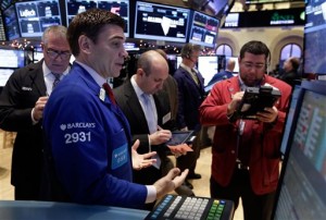 Renaud Laplanche, left, founder & CEO of Lending Club, and CFO Carrie Dolan, huddle with specialist Glenn Carell as they wait for their company's IPO to begin trading, on the floor of the New York Stock Exchange, Thursday, Dec. 11, 2014. Lending Club, a peer-to-peer lending platform, rose $8.56, or 57 percent, to $23.66 on its first day of trading. US stocks advanced Thursday following an upbeat retail sales report, but the gains were limited by concerns over the rapid fall in oil prices.  AP PHOTO/RICHARD DREW
