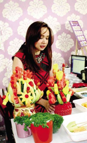 Noeme prepares the fruit bouquets for delivery.