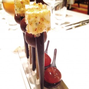 AMUSE bouche of goat cheese coated with caramelized pork, foie gras lollipop coated in chocolate, and limoncello jelly.
