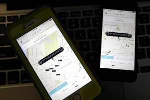FILE - This Friday, Nov. 21, 2014 file photo taken in Newark, N.J., shows smart phones displaying Uber car availability in New York. AP