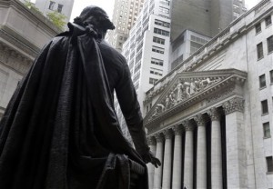 In this Oct. 2, 2014, file photo, the statue of George Washington on the steps of Federal Hall faces the facade of the New York Stock Exchange. A massive snowstorm descending on New York dulled Wall Street trade Monday but stocks ended a bit higher, helped by some positive quarterly earnings reports.  AP PHOTO/RICHARD DREW