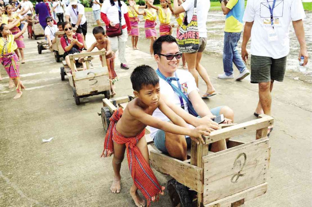 CHILDREN and tourists take turns riding the “Taltalak” (wooden kart) at the Naneng Heritage Village.  