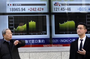 People walk past an electronic board displaying Japan's Nikkei stock index and other financial indexes in Tokyo on Thursday, March 12, 2015. Asian stock markets mostly rose Thursday, finding a firmer footing after several days of volatile trading linked to anxiety over a probable rate hike in the US.  AP PHOTO/SHUJI KAJIYAMA