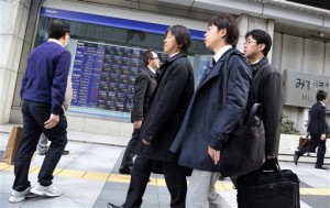 People walk by an electronic stock board of a securities firm in Tokyo on March 13, 2015. Shanghai was the stand-out stock market in the region on Monday, March 16, extending last week's gains after Chinese Premier Li Keqiang said the government had enough in its armory to support the world's No. 2 economy.  AP PHOTO/KOJI SASAHARA 