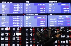 A TV cameraman walks past an electronic board showing Japan stock prices at Tokyo Stock Exchange in Tokyo Thursday, March 12, 2015. Asian stock markets mostly rose Thursday, finding a firmer footing after several days of volatile trading linked to anxiety over a probable rate hike in the U.S.  AP PHOTO/SHUJI KAJIYAMA