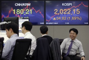A currency trader sits in front of screens showing the Korea Composite Stock Price Index (KOSPI), right, and foreign exchange rate at the foreign exchange dealing room of the Korea Exchange Bank headquarters in Seoul, South Korea, Tuesday, March 17, 2015. Asian stock markets mostly pushed higher Tuesday, while the dollar eased after weak data appeared to pour cold water on talk of an early summer US interest rate rise.  AP PHOTO/AHN YOUNG-JOON 
