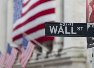 A Wall Street sign hangs near the New York Stock Exchange, in New York. Wall Street stocks notched solid gains Monday, March 9, 2015, following the launch of Apple's smartwatch and a General Motors announcement of $5 billion in share buybacks.  AP Photo/Jin Lee  