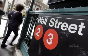 In this Oct. 2, 2014, file photo, people pass a Wall Street subway stop, in New York's financial district. US stocks tumbled Tuesday, May 5, 2015, on worries about higher oil prices and a spike in tensions over the Greek debt crisis.  AP PHOTO/RICHARD DREW 