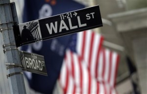 This Oct. 2, 2014, file photo shows a Wall Street sign adjacent to the New York Stock Exchange, in New York. The Dow and S&P 500 closed at fresh highs on Monday, May 18, 2015, following acquisitions in the pharmaceutical and apparel sectors and a rise in Dow member Apple.  AP PHOTO/RICHARD DREW