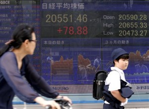 People pass by Japan's Nikkei stock index displayed on an electronic board in Tokyo on Thursday, May 28, 2015. Asian stocks were mostly lower Thursday as a deadline for Greece to make a debt payment neared.  AP PHOTO/SHUJI KAJIYAMA 