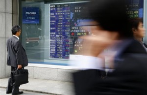 A man looks at an electronic stock indicator of a securities firm in Tokyo, Thursday, May 21, 2015. Shanghai advanced on Thursday after another tepid reading on Chinese manufacturing activity that will likely raise hopes for fresh monetary easing, while Tokyo edged up to a new 15-year high.  AP PHOTO/SHIZUO KAMBAYASHI 