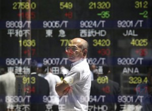 A man is reflected on an electronic stock board of a securities firm in Tokyo on Monday, May 11, 2015. Asian stocks rose on Monday after China’s central bank cut interest rates in the latest move by policymakers to reinvigorate the country’s stumbling economy.  AP PHOTO/KOJI SASAHARA