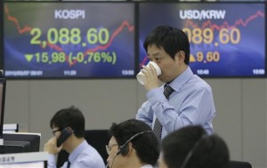 A currency trader drinks water in front of the Korea Composite Stock Price Index (KOSPI), left, and foreign exchange rate at the foreign exchange dealing room of the Korea Exchange Bank headquarters in Seoul, South Korea Thursday, May 7, 2015. Asian markets drooped Thursday after comments from the U.S. Federal Reserve chief fanned fears about the American economy and sent Wall Street lower.  AP PHOTO/AHN YOUNG-JOON 