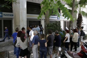 People stand in a queue to use ATMs of a bank in central Athens, Sunday, June 28, 2015. Greece weighed drastic banking restrictions to stave off a financial collapse on Sunday as anxious Greeks emptied cash machines amid fears that banks will be closed this week.  AP PHOTO/THANASSIS STAVRAKIS