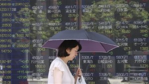 A woman walks by an electronic stock board of a securities firm in Tokyo on Monday, June 1, 2015. Weak Chinese manufacturing data boosted stock markets in Shanghai and Hong Kong on Monday as investors speculated on the rising likelihood of new stimulus measures. Other Asian benchmarks fell as unease over waning US growth and delays in reaching an agreement on Greece's bailout terms spilled into the new week.  AP PHOTO/KOJI SASAHARA