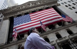 In this Monday, Aug. 8, 2011, file photo, a man walks past the New York Stock Exchange in New York. Wall Street stocks rose Wednesday following a wave of mostly solid US data and a fresh confirmation of ultra-easy money policies by the European Central Bank.  AP PHOTO/JIN LEE 