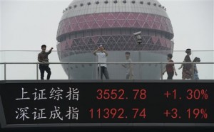 People walk on a footbridge with an electronic stock ticker showing real time stock market indices at Lujiazhui Financial and Trade Zone in Shanghai, China, on Thursday, July 9, 2015. Asian stock markets rebounded on Thursday led by gains on China's main index, which jumped after government measures aimed at stabilizing the market took hold. The Chinese characters at left reads "Shanghai Composite Index, Shenzhen Component Index."  CHINATOPIX VIA AP