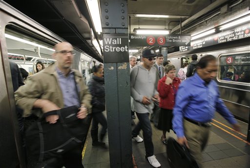 In this Oct. 8, 2014, file photo, commuters rush from subway trains at a Wall Street station, in New York. The Nasdaq edged up to a third straight record high Monday, July 20, 2015, as solid earnings from toymaker Hasbro and others kicked off a heavy week of quarterly results.  AP PHOTO/MARK LENNIHAN