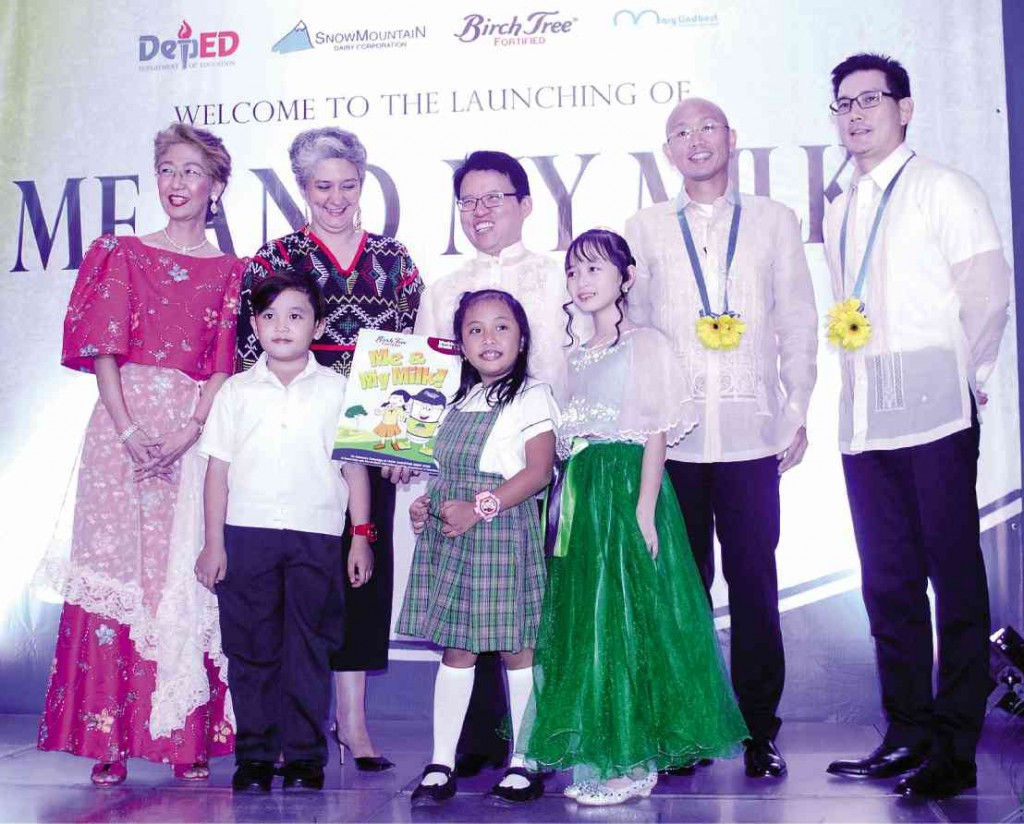 EDUCATION Undersecretary Dina Ocampo (secpnd from left) joins (from left) Mary Lindbert International CEO Erlinda Legaspi, Africa, child actress and co-endorser Mutya Orquia, Century Pacific Food Inc. president and CEO Christopher Po, actor and brand co-endorser Richard Yap in turning over the workbook to two schoolchildren, which is one of the components of the “Me and My Milk” advocacy program. photo by Romy Homillada 