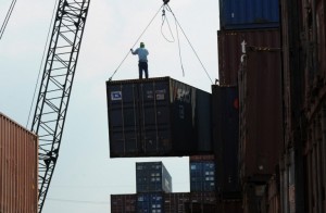 A worker stands on a container at a port in Manila on February 24, 2015.The Philippines on Monday, July 6, 2015, secured another credit-rating upgrade from Japan Credit Rating Agency Ltd. (JCR), which was also the highest that the country has received from major international debt watchers.  AFP PHOTO/TED ALJIBE