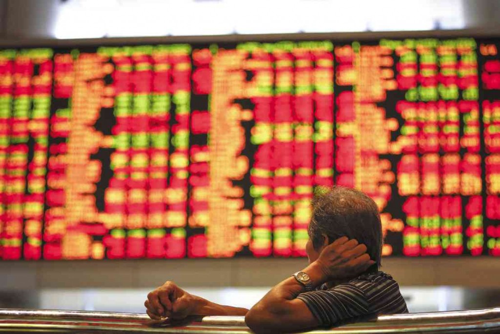 A MAN watches the trading board at a private stock market gallery in Kuala Lumpur, Malaysia. Asian markets mostly fell Monday as investors reacted to Greece’s sound rejection of terms set by its international creditors. AP