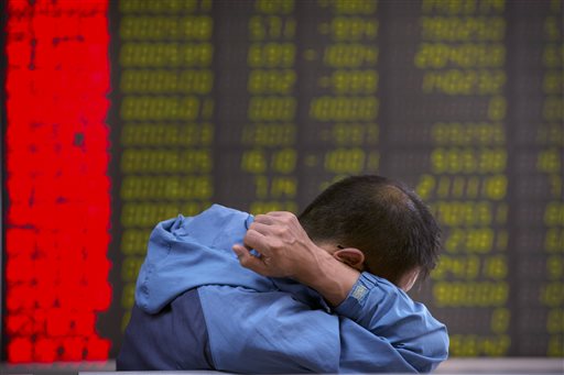 A Chinese investor monitors stock prices at a brokerage house in Beijing, Tuesday, Aug. 25, 2015.  China's main stock market index has fallen for a fourth day, plunging 7.6 percent to an eight-month low.  (AP Photo/Mark Schiefelbein)