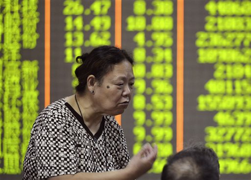 A Chinese stock investor gestures near a board with green numbers representing falling stocks at a brokerage house in Hangzhou in eastern China's Zhejiang province Tuesday, Aug. 25, 2015. Chinese stocks tumbled again Tuesday after their biggest decline in eight years while most other Asian markets rebounded from a day of heavy losses. AP