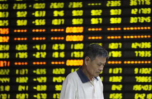 In this photo provided by China's Xinhua News Agency, a man walks past stock market quotation on display at a business lobby of a security company in Huaibei, east China's Anhui Province, Monday, July 27, 2015. AP