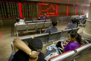 Chinese investors monitor displays of stock information at a brokerage house in Beijing on July 28, 2015. Asian markets fell Monday, Aug. 3, as China shares were dragged down by poor manufacturing figures and investors followed a drop on Wall Street.  AP PHOTO/MARK SCHIEFELBEIN 