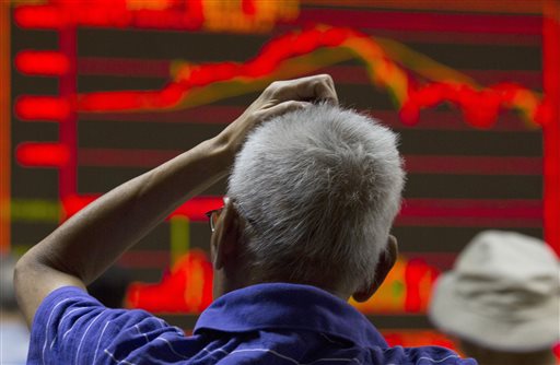 An investor scratches his head near an electronic board displaying market movements at a brokerage in Beijing, Monday, Aug. 31, 2015. Asian stocks fell Monday after a US Federal Reserve official suggested a September interest rate hike still was possible and Japanese factory activity weakened.   AP PHOTO/NG HAN GUAN