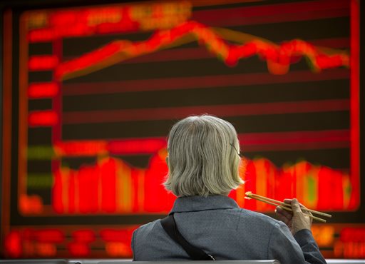 A Chinese investor eats lunch as she monitors stock prices at a brokerage house in Beijing, Wednesday, Sept. 16, 2015. Asian stocks rose Wednesday, tracking gains on Wall Street as investor optimism mounted ahead of a highly anticipated Federal Reserve policy meeting. (AP Photo/Mark Schiefelbein)