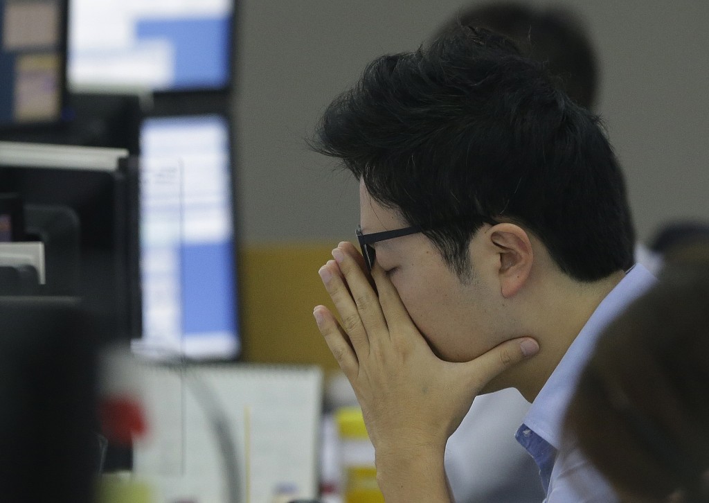 A currency trader rubs his eyes at the foreign exchange dealing room of the KEB Hana Bank headquarters in Seoul, South Korea, Friday, Sept. 4, 2015. Asian stock markets were mostly lower Friday as caution prevailed before the release of the monthly U.S. jobs report and the resumption of trading on Chinese stock markets next week. (AP Photo/Ahn Young-joon)
