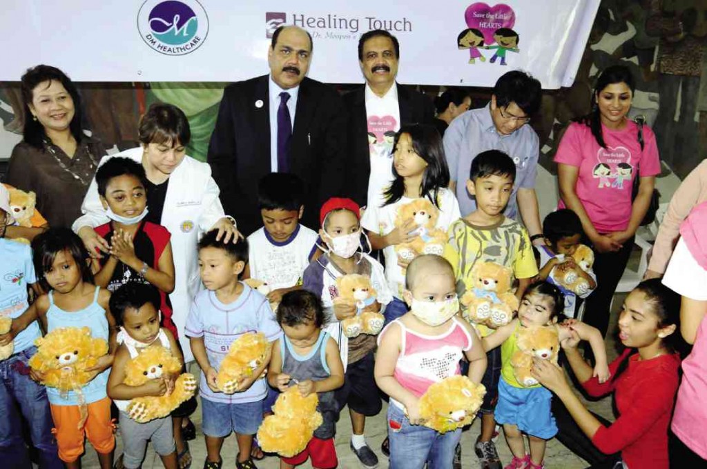 MOOPEN (back, wearing  coat over a collared shirt with the Save the Little Hearts logo) visited the Philippines in 2013 to oversee the launch of a program to help for free, poor children with congenital heart defect.